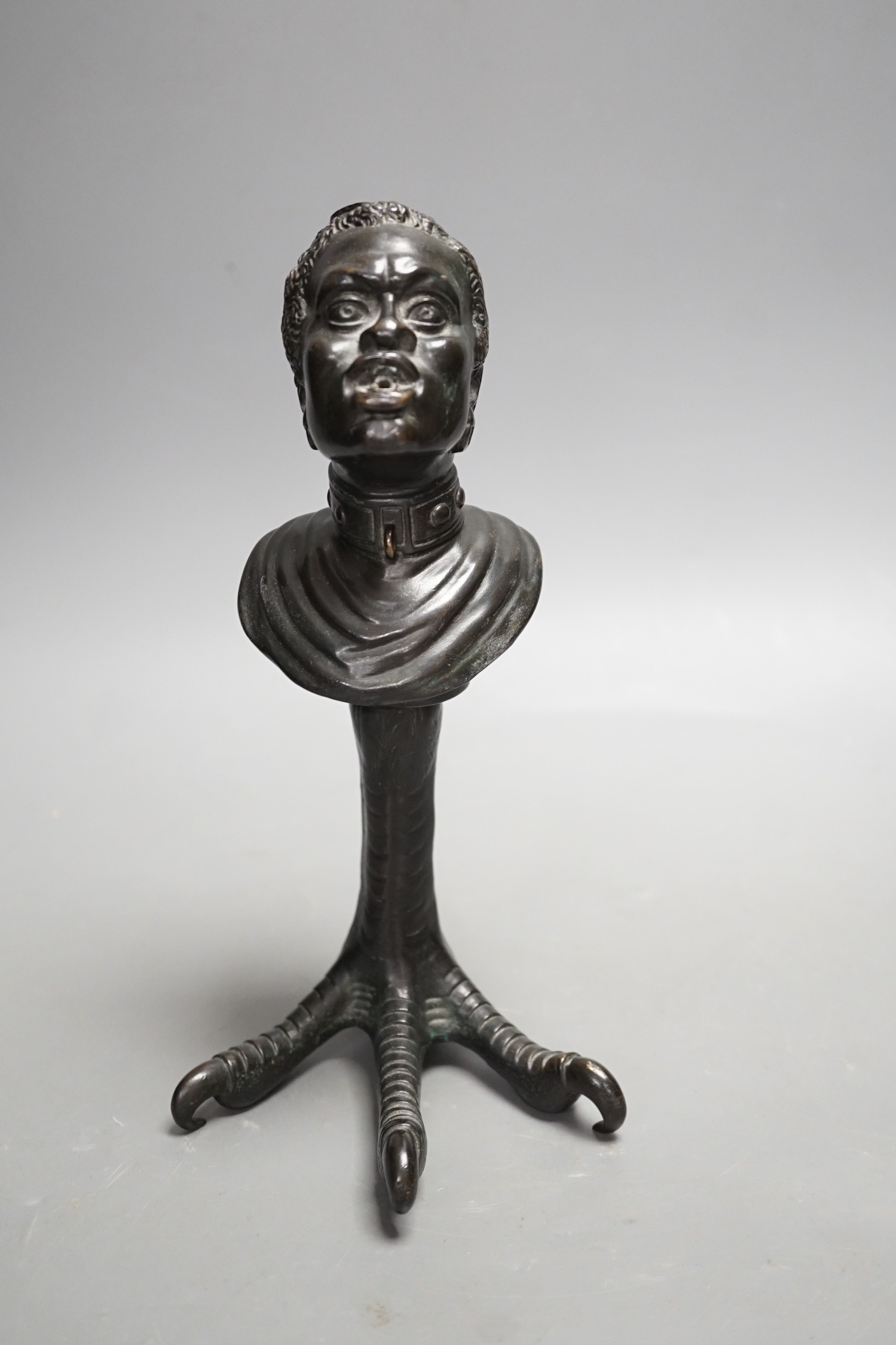 A bronze slave portrait bust on claw stand. 23cm high